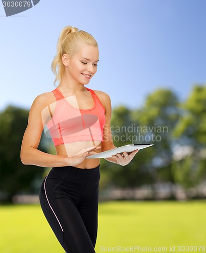 Image of smiling sporty woman with tablet pc computer