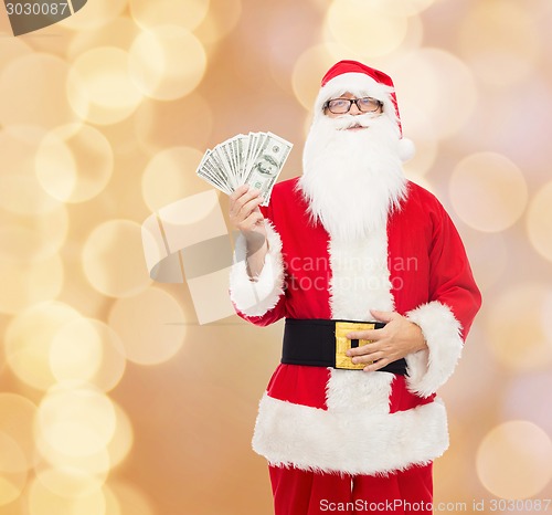 Image of man in costume of santa claus with dollar money