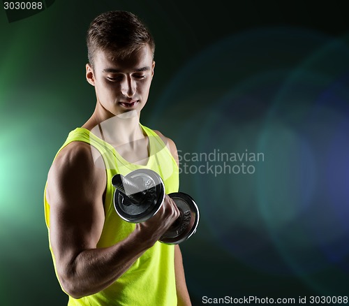 Image of young man with dumbbell flexing biceps