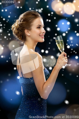 Image of smiling woman holding glass of sparkling wine