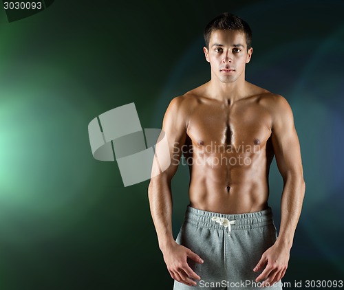 Image of young male bodybuilder with bare muscular torso