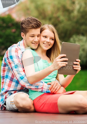 Image of smiling couple with tablet pc making selfie
