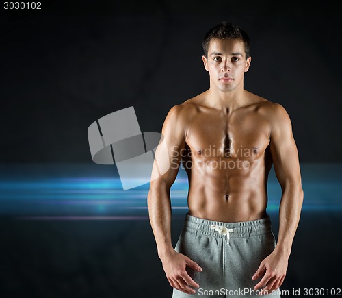 Image of young male bodybuilder with bare muscular torso