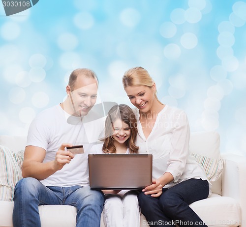 Image of happy family with laptop computer and credit card