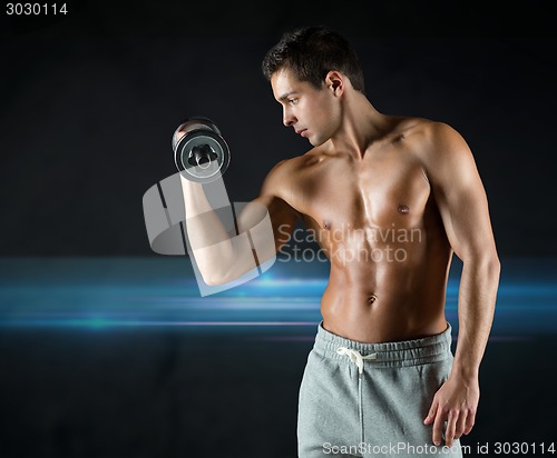 Image of young man with dumbbell flexing biceps