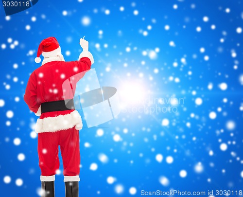 Image of man in costume of santa claus writing something