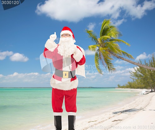 Image of man in costume of santa claus pointing finger up