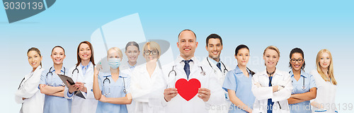 Image of group of smiling doctors with red heart shape