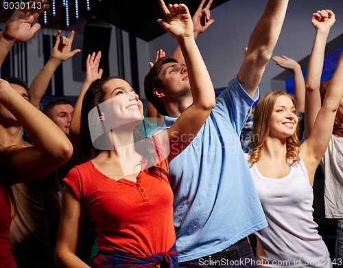 Image of smiling friends at concert in club