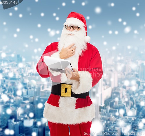 Image of man in costume of santa claus with notepad