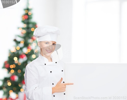 Image of smiling female chef with white blank board