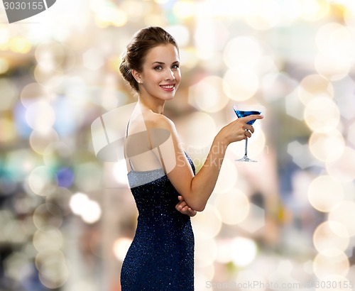 Image of smiling woman holding cocktail