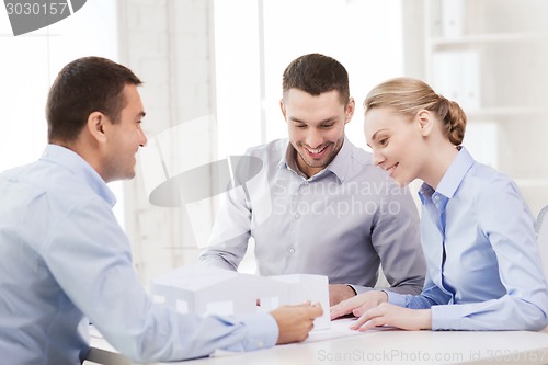 Image of couple looking at model of their house at office