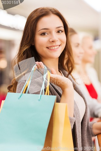 Image of happy young women with shopping bags in mall