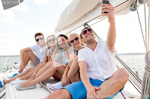 Image of smiling friends sitting on yacht deck