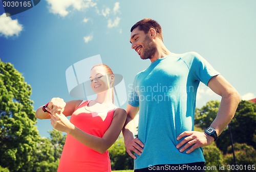 Image of smiling people with heart rate watches outdoors