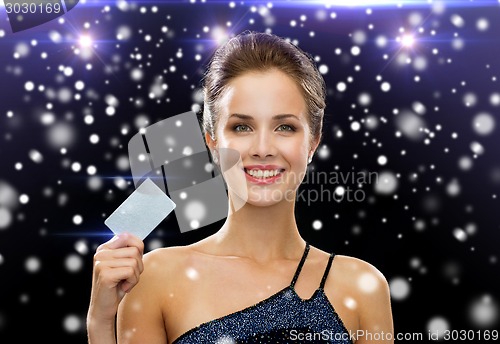 Image of smiling woman in evening dress holding credit card