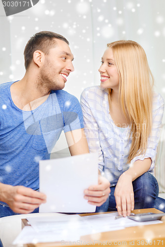 Image of happy couple with papers and calculator at home