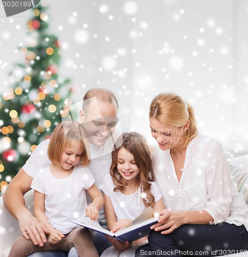 Image of happy family with book at home