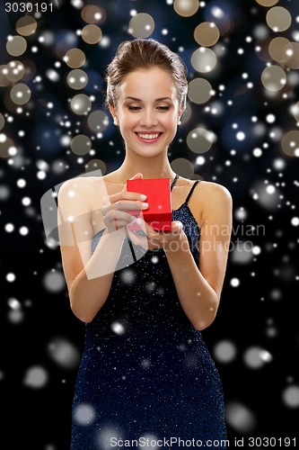 Image of smiling woman holding red gift box