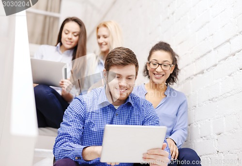 Image of team with tablet pc computer sitting on staircase