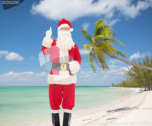Image of man in costume of santa claus pointing finger up