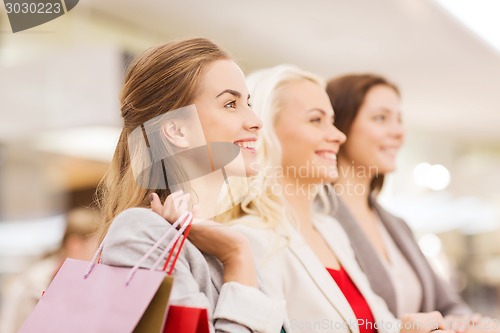 Image of happy young women with shopping bags in mall