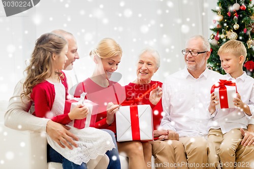 Image of smiling family with gifts at home