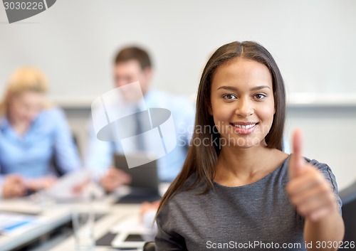 Image of group of smiling businesspeople meeting in office