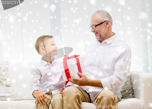 Image of smiling grandfather and grandson at home