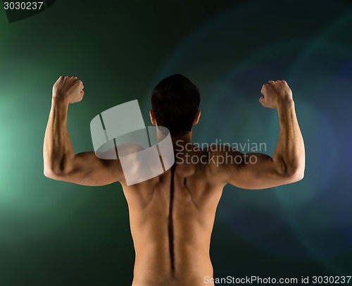 Image of young man showing biceps and muscles