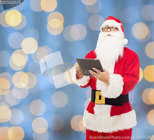 Image of man in costume of santa claus with tablet pc