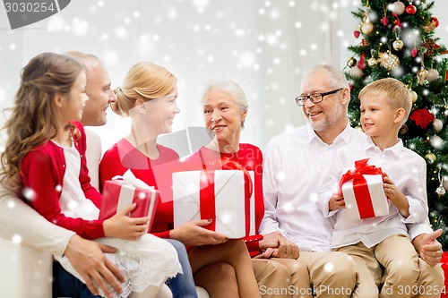 Image of smiling family with gifts at home