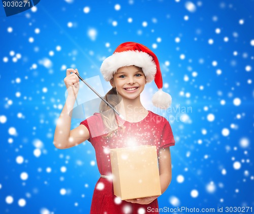 Image of smiling girl in santa helper hat with gift box