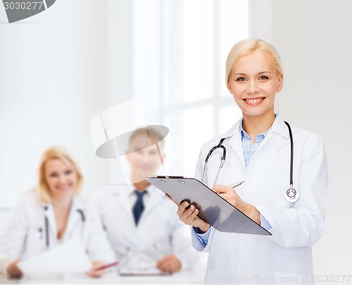 Image of smiling female doctor with clipboard