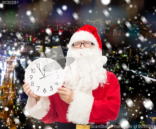 Image of man in costume of santa claus with clock