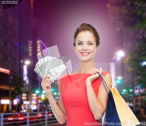 Image of smiling woman with shopping bags and money