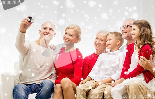 Image of smiling family with camera at home