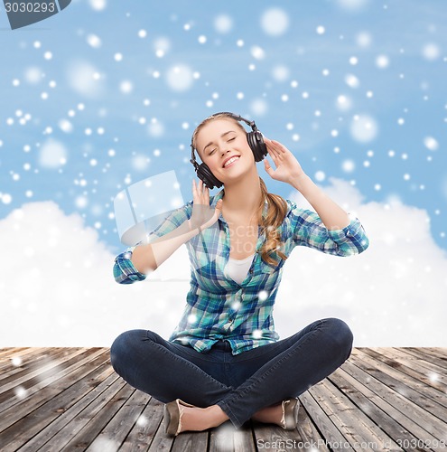 Image of young woman in headphones listening to music