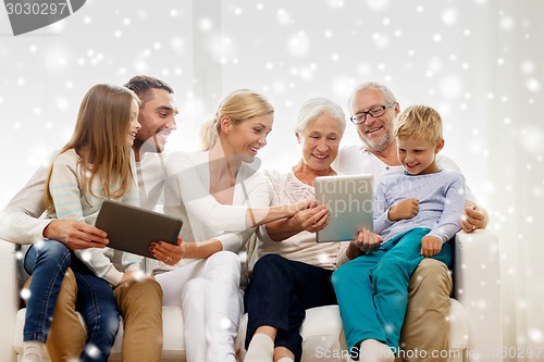 Image of smiling family with tablet pc at home