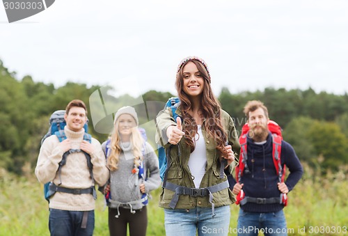 Image of group of smiling friends with backpacks hiking