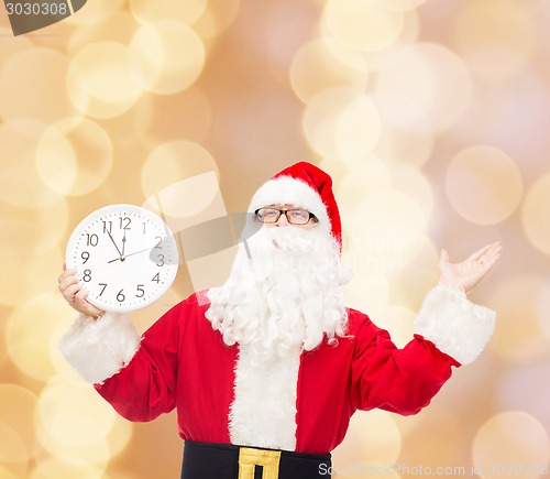 Image of man in costume of santa claus with clock