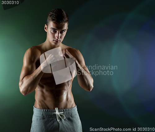 Image of young man in fighting or boxing position