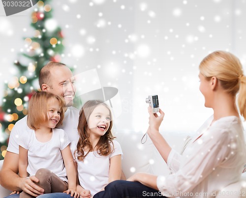 Image of happy family with camera at home