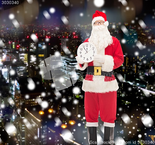 Image of man in costume of santa claus with clock