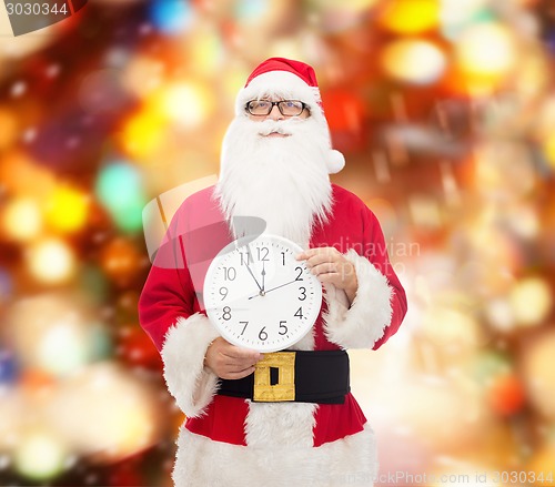 Image of man in costume of santa claus with clock