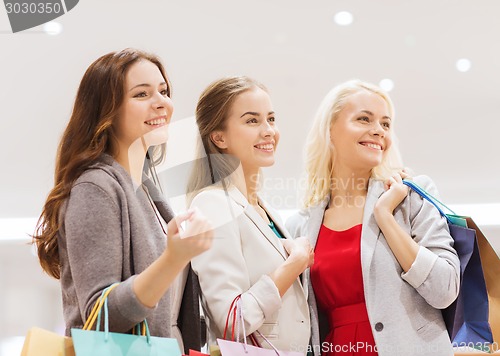 Image of happy young women with shopping bags in mall