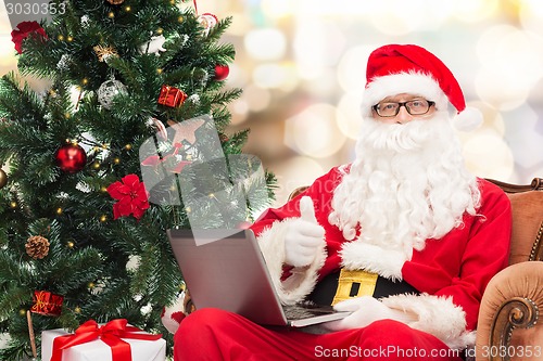 Image of man in costume of santa claus with laptop