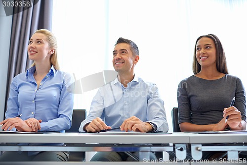 Image of smiling business people meeting in office
