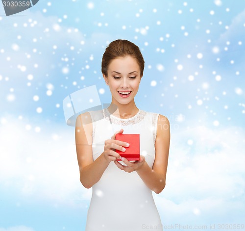 Image of smiling woman holding red gift box